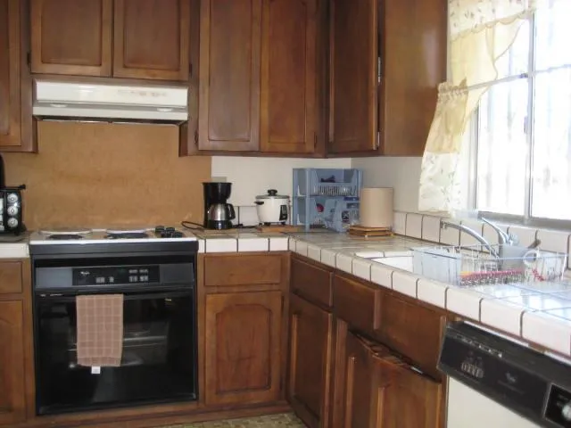 a kitchen with granite countertop a sink cabinets and stainless steel appliances