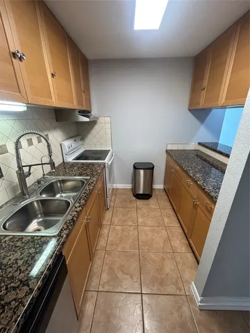 a kitchen with sink a stove and cabinets