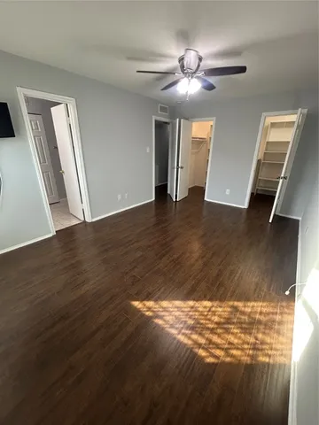 a view of a livingroom with wooden floor and a ceiling fan