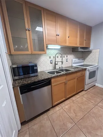 a kitchen with granite countertop a sink and cabinets
