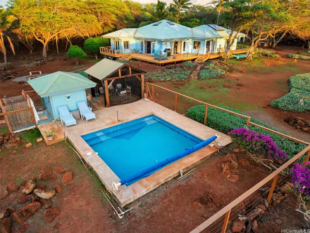 an aerial view of residential houses with outdoor space and ocean view