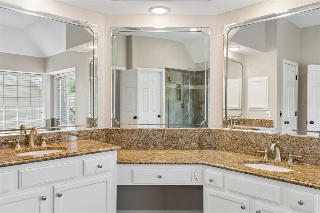 2925 Sunset Ridge McKinney, TX 75072 - Photo 26 of 33 Another view of the sophisticated primary bath vanity area showcasing granite countertops, oversized framed mirrors, dual sinks, and abundant counter space designed for both style and convenience.