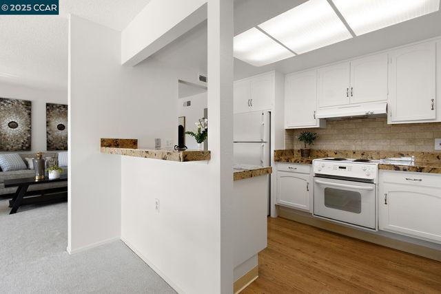 a kitchen with kitchen island granite countertop a sink cabinets stainless steel appliances and a counter space