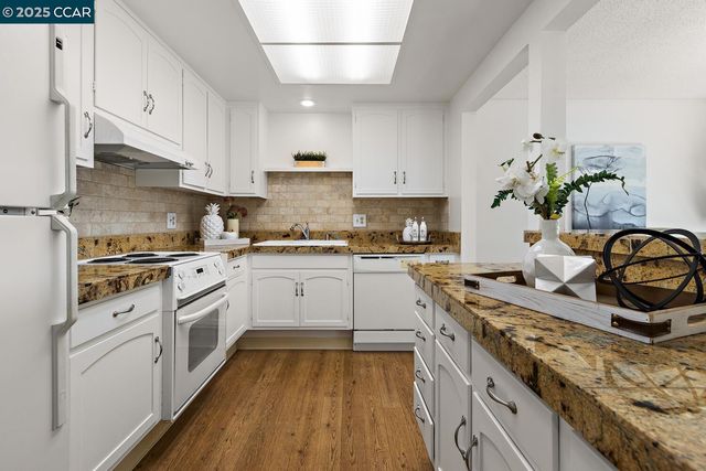 a kitchen with kitchen island granite countertop a sink and a stove