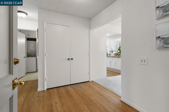 a view of a hallway with wooden floor and a bathroom