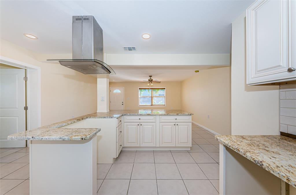 713 Pruitt Drive Madeira Beach, FL 33708 - Photo 11 of 62 a kitchen with granite countertop a sink and a stove