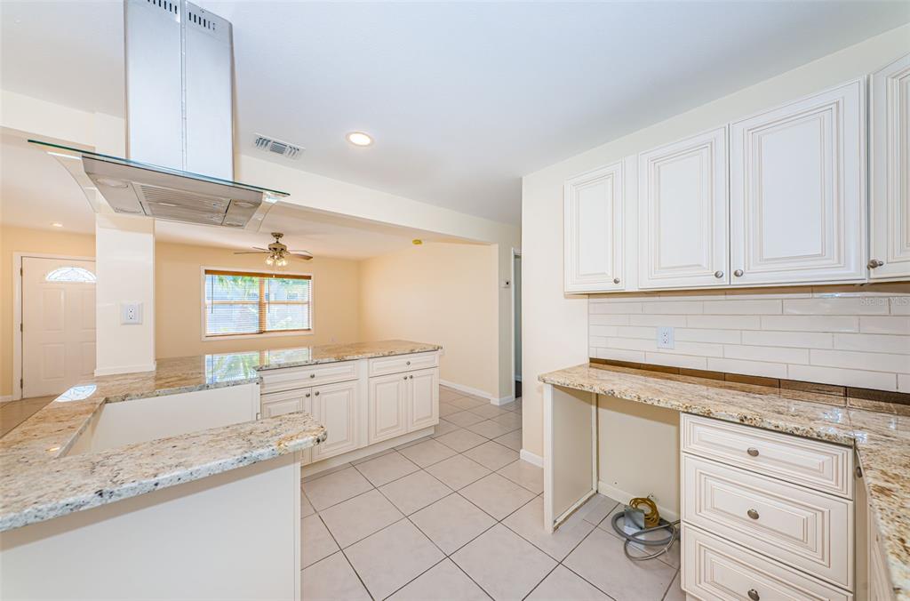 713 Pruitt Drive Madeira Beach, FL 33708 - Photo 10 of 62 a kitchen with granite countertop white cabinets and white appliances
