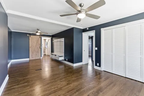wooden floor in an empty room and a ceiling fan view
