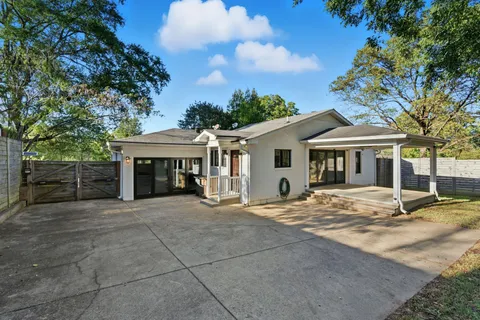 a front view of a house with yard and parking