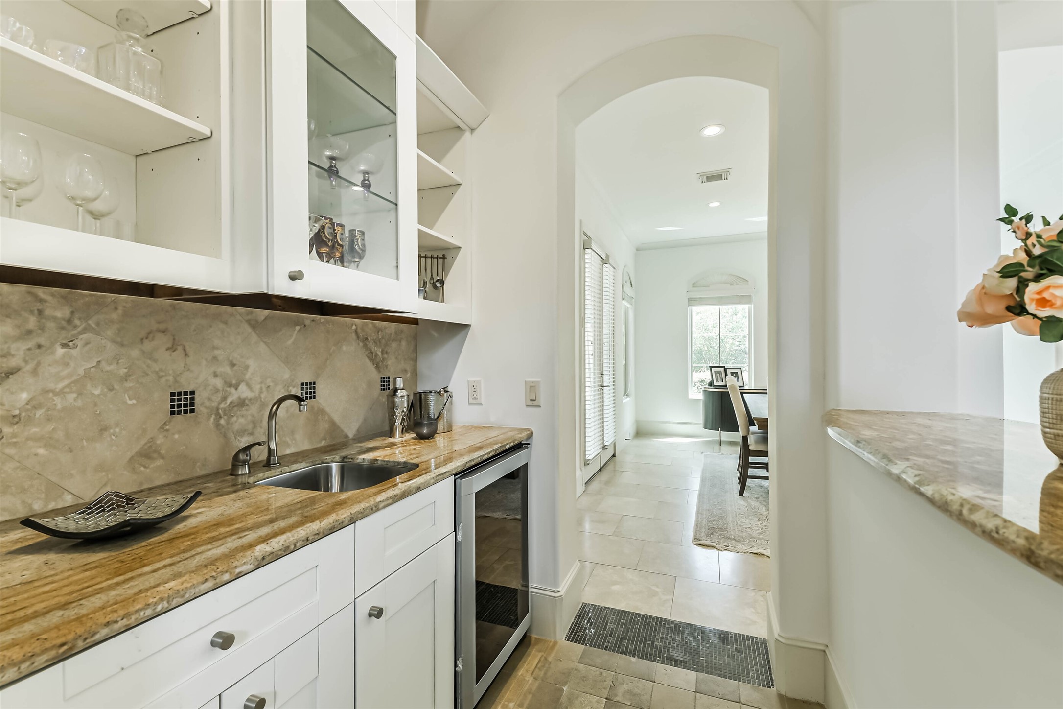 2502 Chimney Rock Road Houston, TX 77056 - Photo 19 of 50 Elegant wet bar featuring a small wine cooler and leading into the dining room, perfect for entertainment