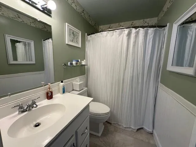 a bathroom with a sink a toilet and shower curtain