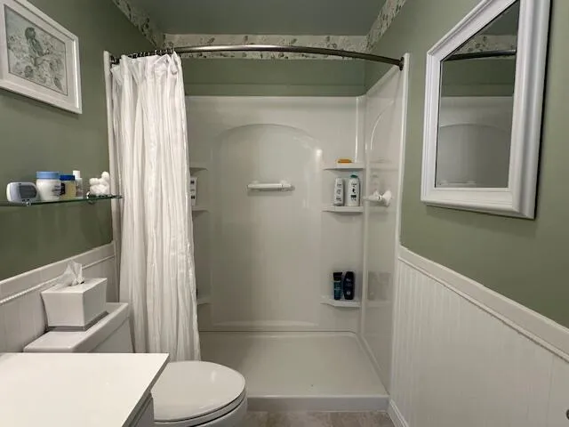 a bathroom with a toilet and a shower