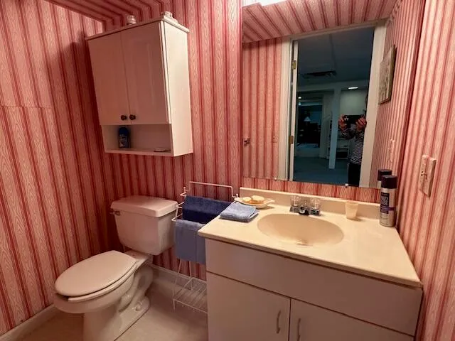 a bathroom with a sink and mirror with toilet