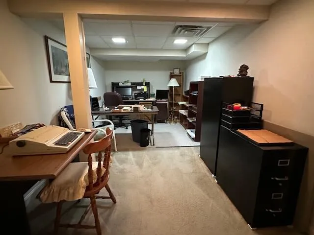 a work room with furniture a lamp and a flat screen tv