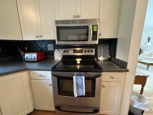 a kitchen with stainless steel appliances granite countertop a stove and a microwave