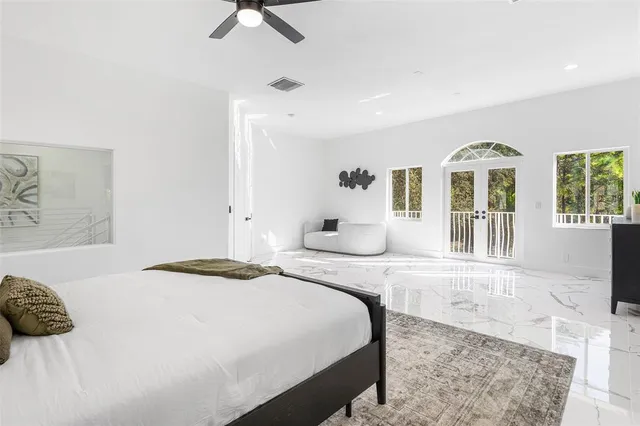 a bedroom with a large bed and a chandelier