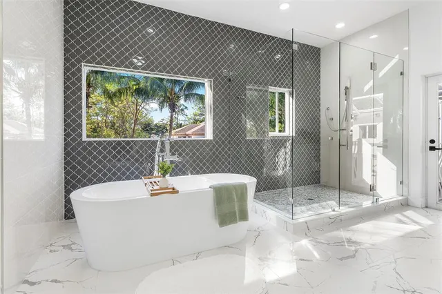 a white bath tub sitting in a bathroom next to a window