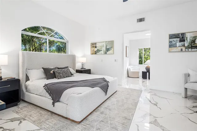 a bedroom with a large bed and a window