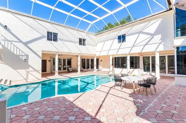an aerial view of residential house with swimming pool and lawn chairs