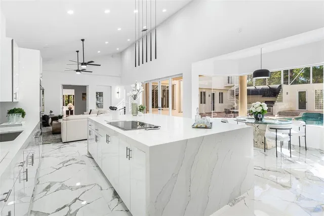 a large white kitchen with lots of counter space and furniture