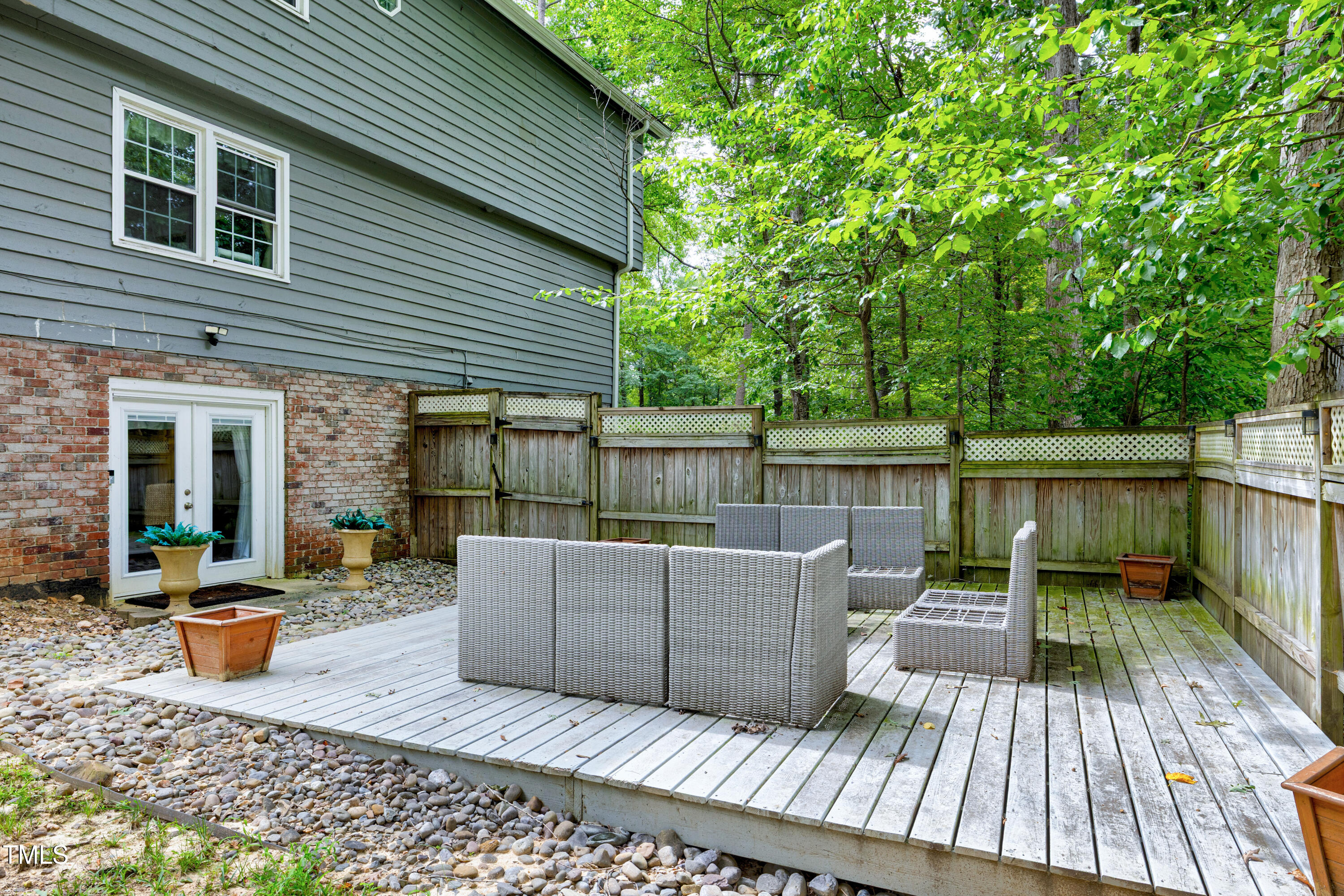 112 Queensferry Road Cary, NC 27511 - Photo 33 of 41 a view of a patio with couches chairs potted plants and floor to ceiling window and wooden fence