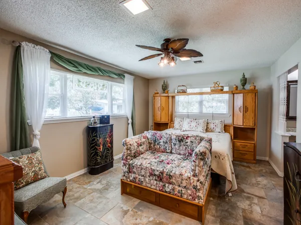 a living room with furniture a large window with kitchen view