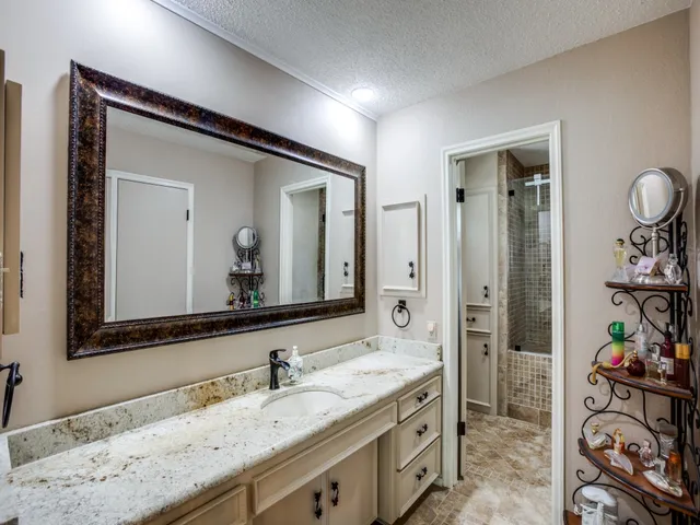 a bathroom with a granite countertop sink and a mirror