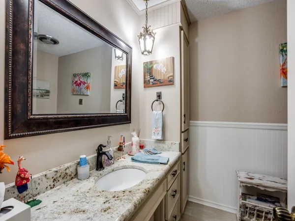 a bathroom with a granite countertop sink mirror and a shower