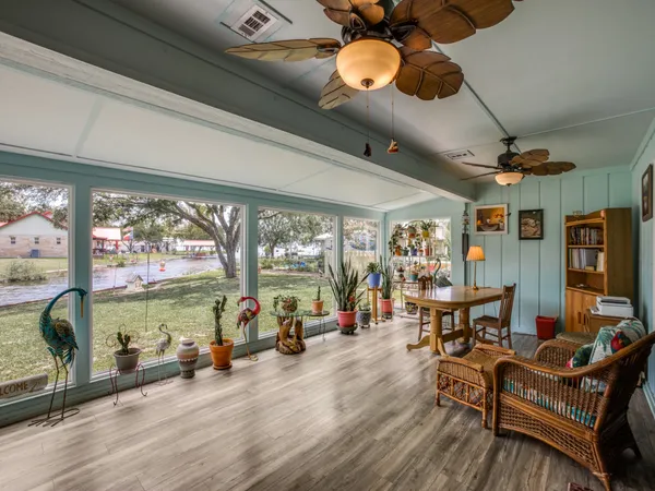 a living room with furniture a floor to ceiling window and a flat screen tv