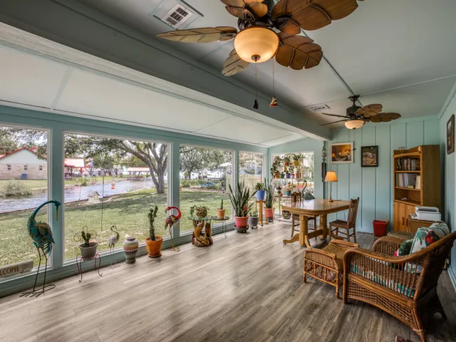 a living room with furniture a floor to ceiling window and a flat screen tv