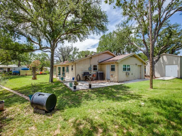 a backyard of a house with garden and outdoor seating
