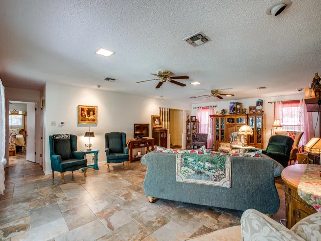 a living room with furniture kitchen view and a large window