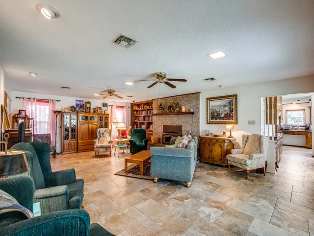 a living room with fireplace furniture and a large window
