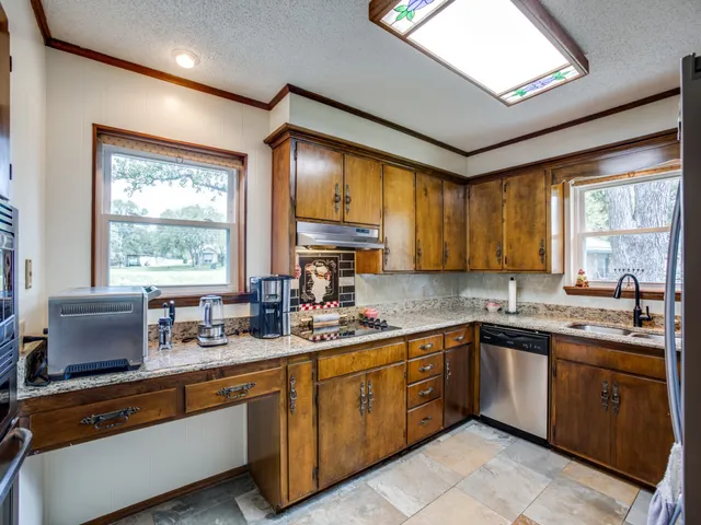 a kitchen with lots of counter top space sink and wooden floor