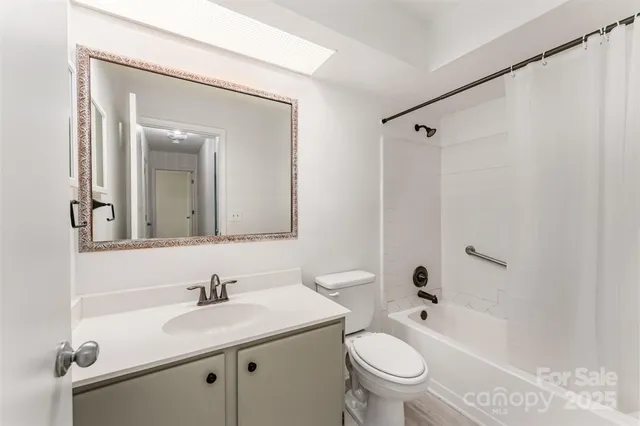a bathroom with a granite countertop sink a toilet and a mirror