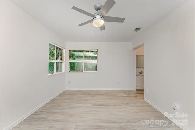 an empty room with window and a ceiling fan
