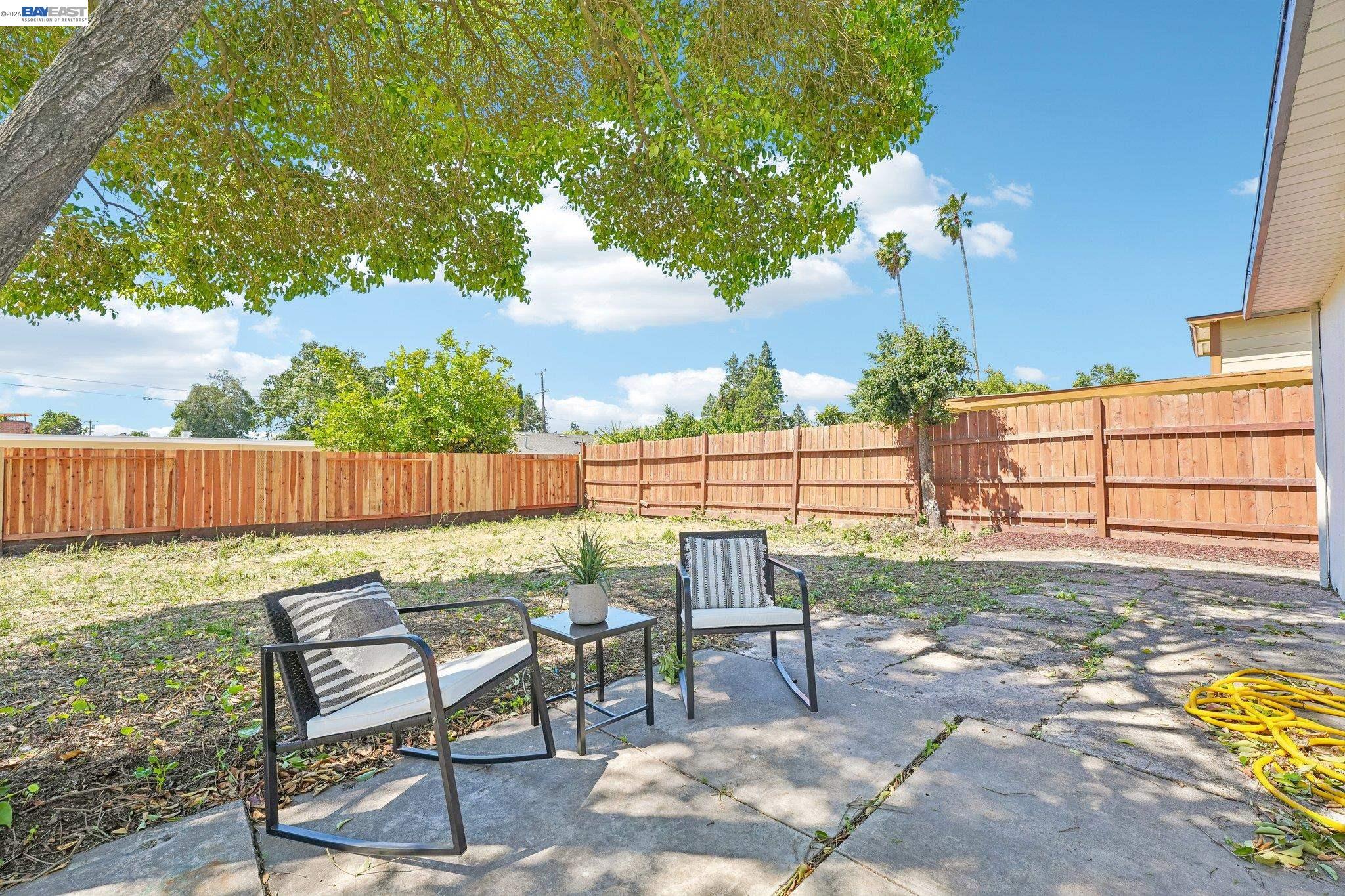 606 West 9th Street Santa Rosa, CA 95401 - Photo 46 of 52 a view of a backyard with chairs potted plants and a palm tree