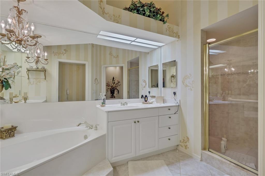 10801 Crooked River Road, Unit 203 Estero, FL 34135 - Photo 23 of 27 a bathroom with a double vanity sink mirror and shower
