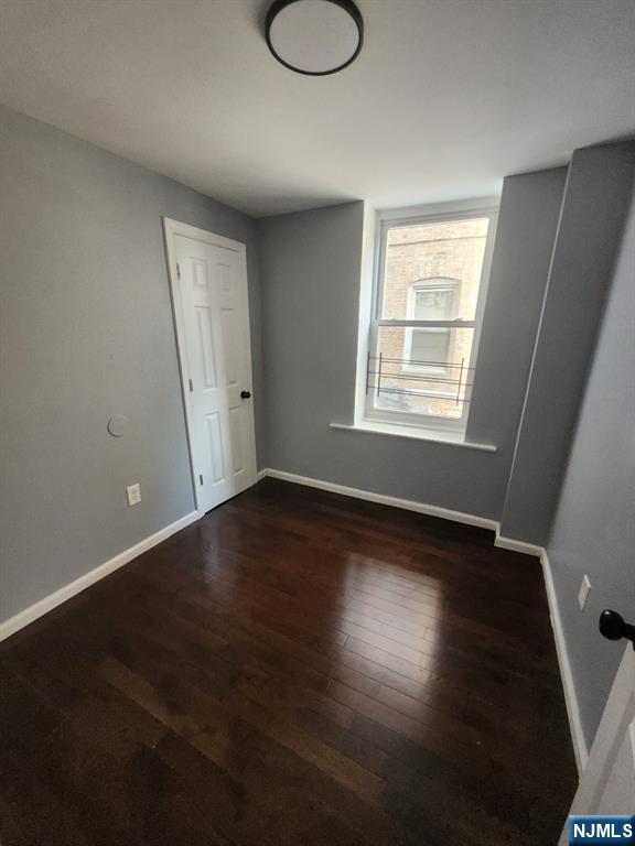 316 South Orange Avenue, Unit BS Newark, NJ 07103 - Photo 3 of 7 an empty room with wooden floor and windows