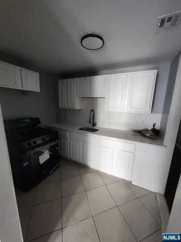 a kitchen with a stove a sink and a cabinets