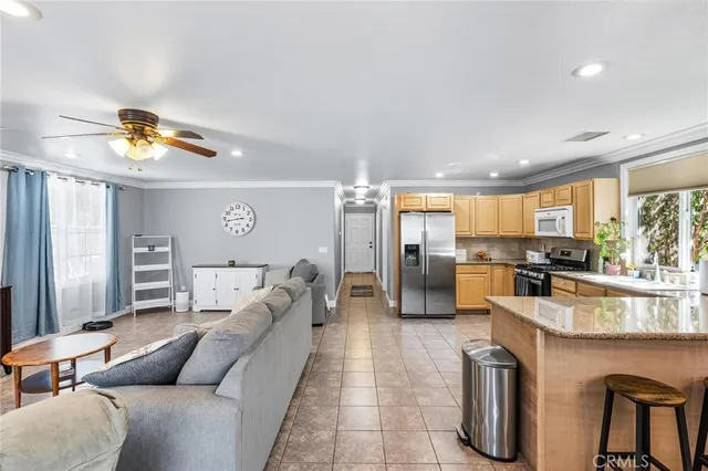 a living room with stainless steel appliances kitchen island granite countertop furniture and a view of kitchen