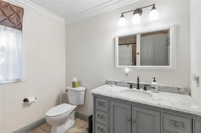 a bathroom with a granite countertop sink a toilet and a mirror