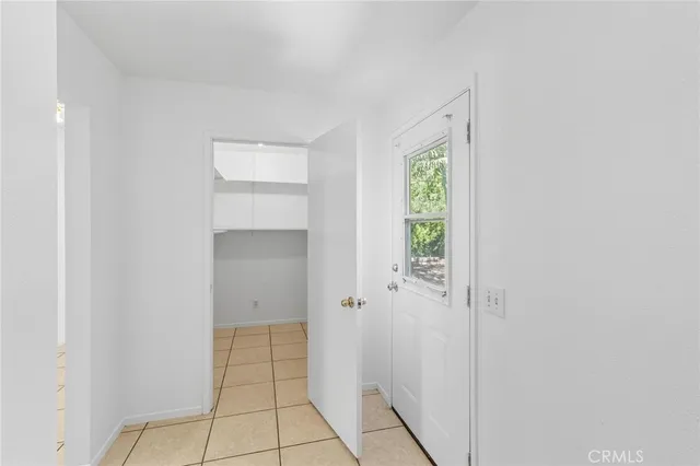 a view of an empty room with cabinet and mirror