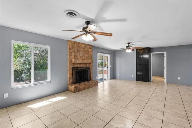 a view of an empty room with a fireplace and a window
