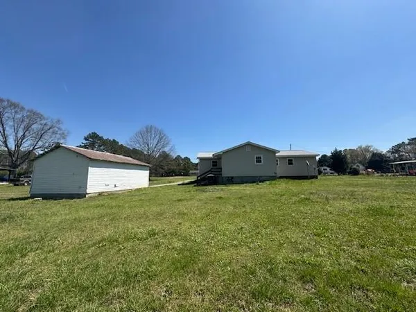 a house with green field in front of it