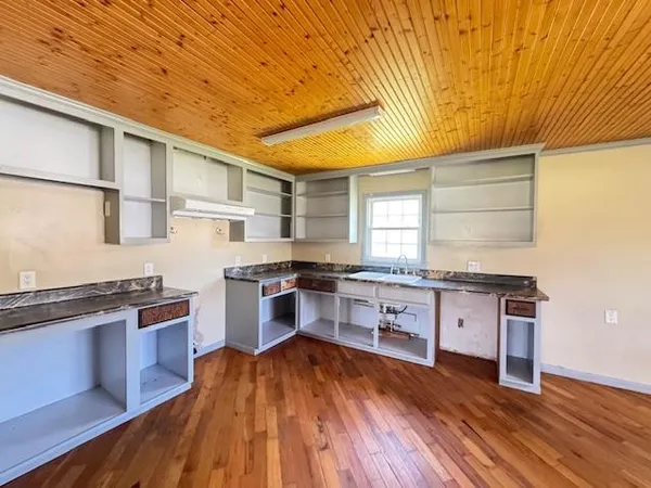 a large kitchen with stainless steel appliances granite countertop a large counter top a stove and a refrigerator