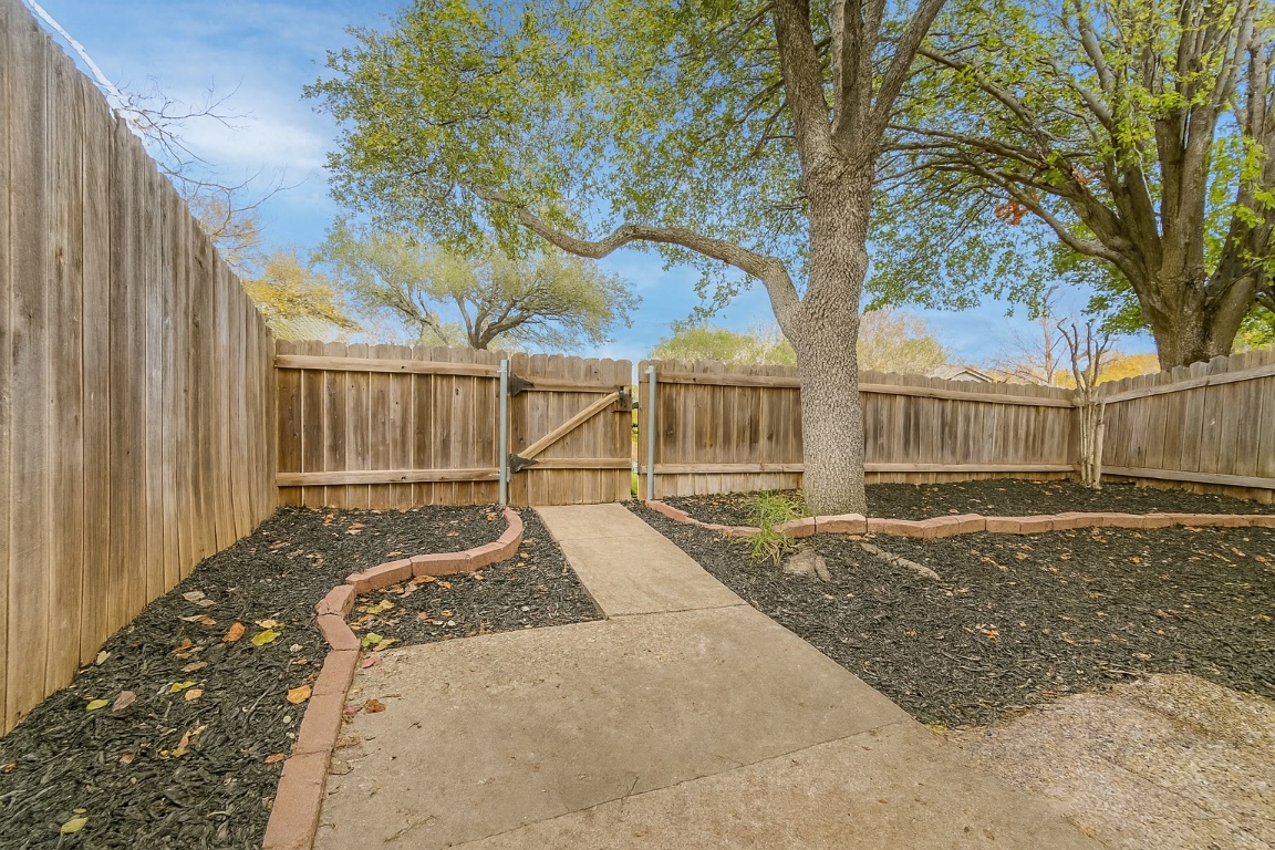 1015 East Yager Lane, Unit 51 Austin, TX 78753 - Photo 2 of 11 a view of a house with a small yard and wooden fence
