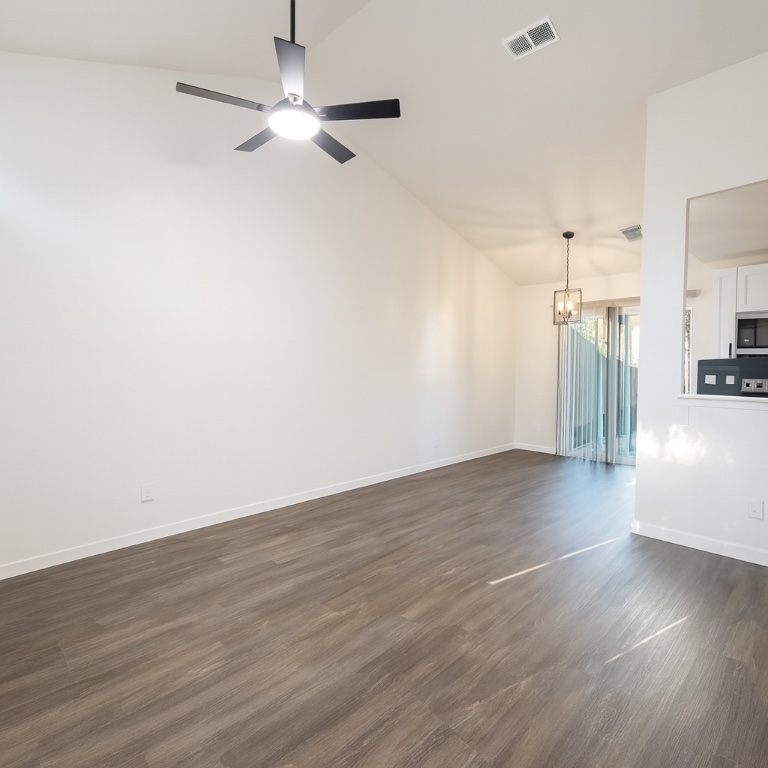 1015 East Yager Lane, Unit 51 Austin, TX 78753 - Photo 4 of 11 a view of a kitchen with wooden floor a ceiling fan and windows