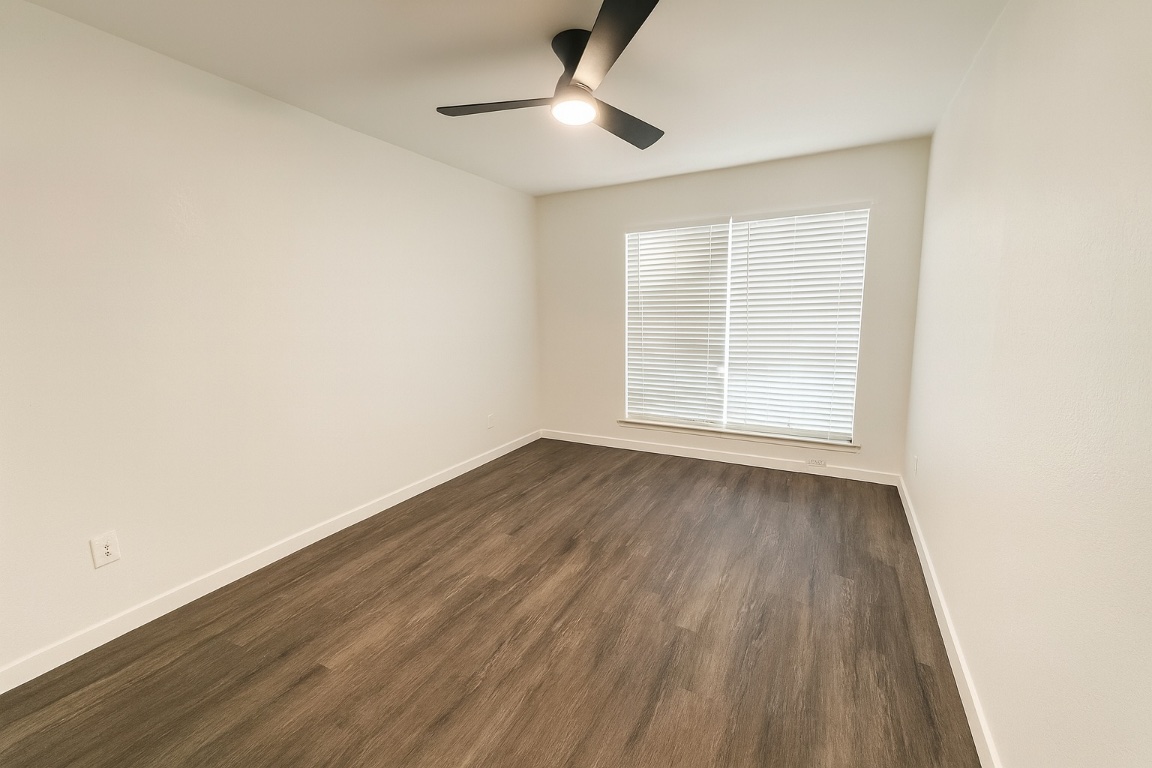 1015 East Yager Lane, Unit 51 Austin, TX 78753 - Photo 7 of 11 wooden floor in an empty room with a window