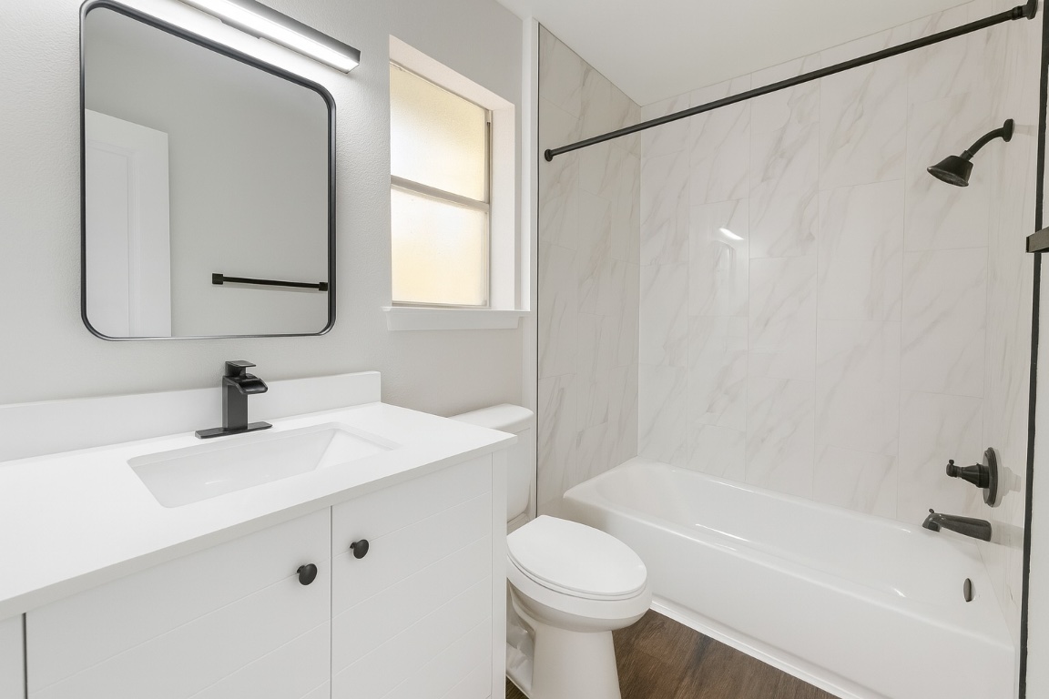 1015 East Yager Lane, Unit 51 Austin, TX 78753 - Photo 8 of 11 a bathroom with a sink mirror toilet and bathtub